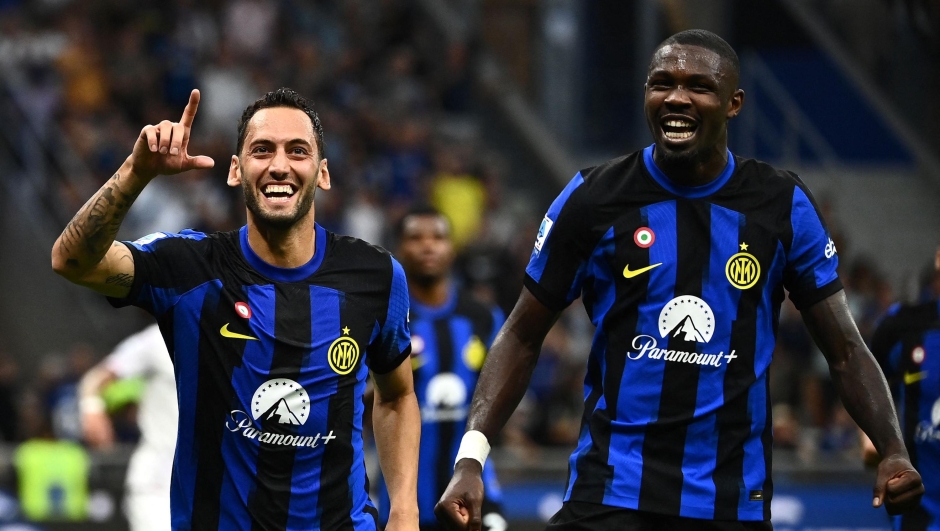 Inter Milan's Turkish midfielder #20 Hakan Calhanoglu celebrates with Inter Milan's French forward #09 Marcus Thuram (R) after scoring a penalty during the Italian Serie A football match between Inter Milan and Fiorentina at San Siro stadium in Milan on September 3, 2023. (Photo by Isabella BONOTTO / AFP)