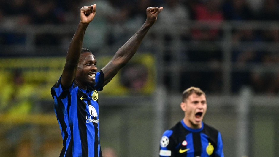 Inter Milan's French forward #09 Marcus Thuram (L) celebrates scoring his team's first goal during the UEFA Champions League 1st round day 2 Group D football match Inter Milan vs Benfica at the San Siro stadium in Milan on October 3, 2023. (Photo by GABRIEL BOUYS / AFP)