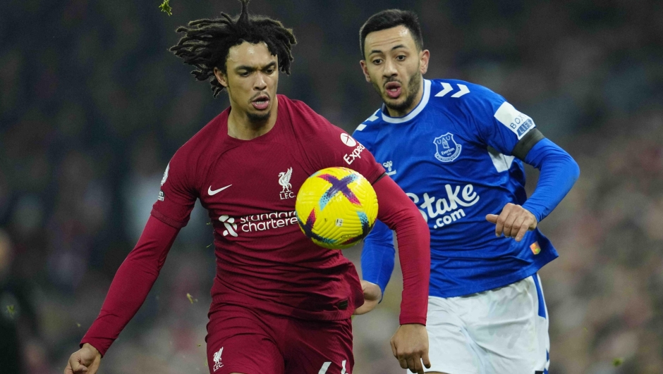 Liverpool's Trent Alexander-Arnold, left, is challenged by Everton's Dwight McNeil during the English Premier League soccer match between Liverpool and Everton at the Anfield stadium in Liverpool, England, Monday, Feb. 13, 2023. (AP Photo/Jon Super)