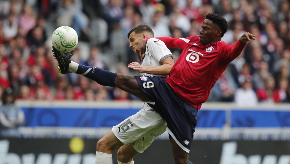 Olimpija's Ahmet Muhamedbegovic and Lille's Jonathan David, right, battle for the ball during the Conference League soccer match between Lille and NK Olimpija Ljubljana, Wednesday, Sept 20, 2023, at the Pierre Mauroy stadium in Villeneuve-d'Ascq, outside Lille northern France. (AP Photo/Michel Spingler)