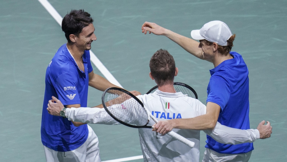 Italy's Jannik Sinner, right, celebrates with his teammate Lorenzo Sonego, left, with Italy's captain Filippo Volandri after winning against Serbia's Novak Djokovic and Miomir Kecmanovic during a Davis Cup semi-final doubles tennis match between Italy and Serbia in Malaga, Spain, Saturday, Nov. 25, 2023. (AP Photo/Manu Fernandez)