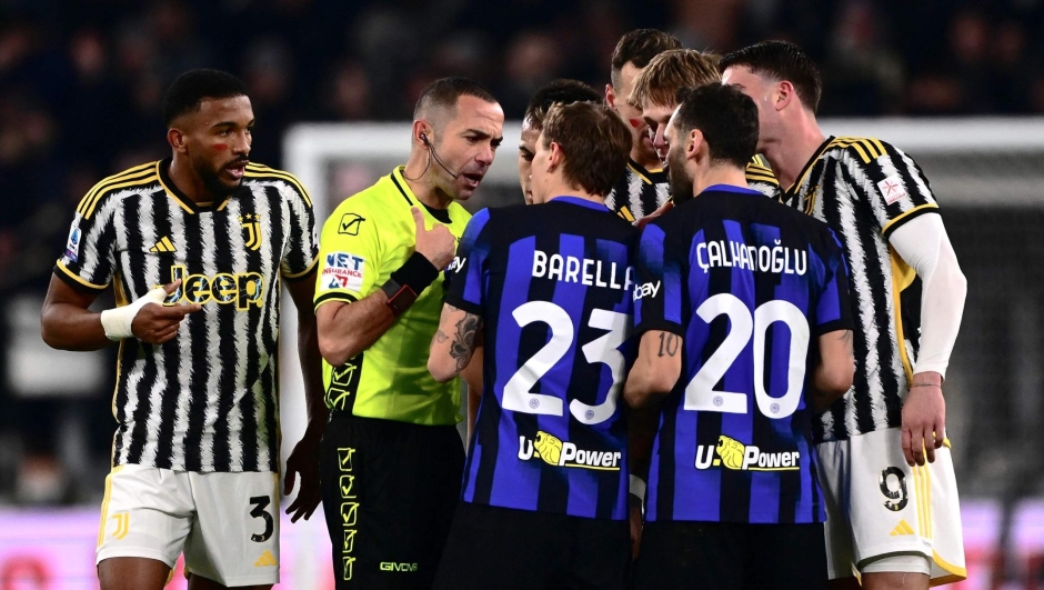 Italian referee Marco Guida (2L) talks to Inter Milan's Italian midfielder #23 Nicolo Barella (C) during the Italian Serie A football match between Juventus and Inter Milan at the Allianz Stadium in Turin, on November 26, 2023. (Photo by MARCO BERTORELLO / AFP)