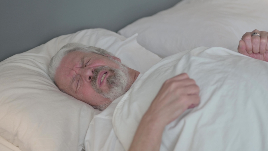 Restless Old Man Trying Sleeping in Bed