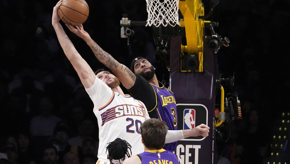 Phoenix Suns center Jusuf Nurkic, left, and Los Angeles Lakers forward Anthony Davis reach for a rebound during the first half of an NBA basketball game Thursday, Jan. 11, 2024, in Los Angeles. (AP Photo/Mark J. Terrill)