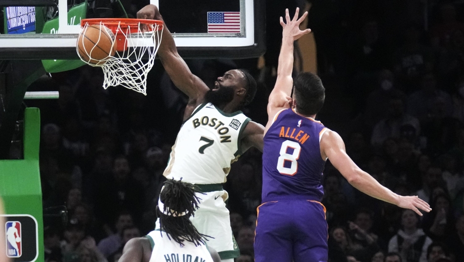 Boston Celtics guard Jaylen Brown (7) dunks after driving past Phoenix Suns guard Grayson Allen (8) during the second half of an NBA basketball game, Thursday, March 14, 2024, in Boston. (AP Photo/Charles Krupa)