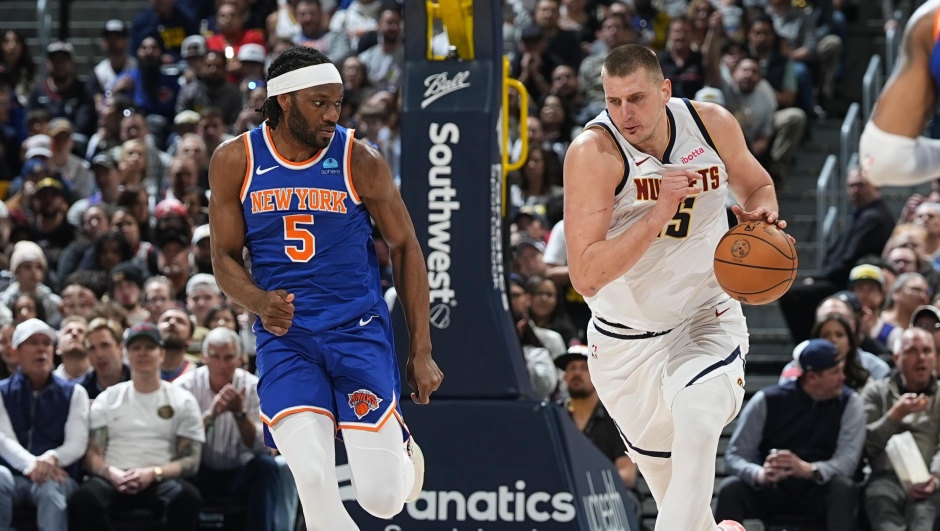 Denver Nuggets center Nikola Jokic, right, heads down the court after collecting a loose ball as New York Knicks forward Precious Achiuwa (5) defends in the second half of an NBA basketball game Thursday, March 21, 2024, in Denver. (AP Photo/David Zalubowski)