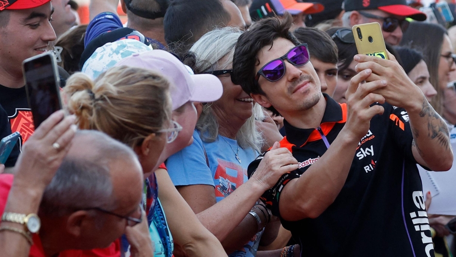 Aprilia Racing Spanish rider Maverick Vinales poses with his fans during the 'MotoGP VIP Village Pit Lane Walk' ahead of the Qatar MotoGP Grand Prix at the Lusail International Circuit in Lusail, north of Doha on March 10, 2024. (Photo by KARIM JAAFAR / AFP)