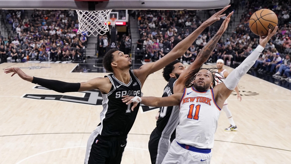 New York Knicks guard Jalen Brunson (11) drives to the basket against San Antonio Spurs center Victor Wembanyama (1) during the second half of an NBA basketball game in San Antonio, Friday, March 29, 2024. (AP Photo/Eric Gay)