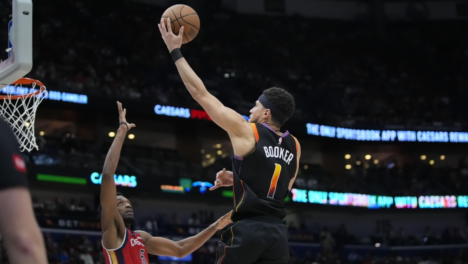 Phoenix Suns guard Devin Booker (1) goes to the basket over New Orleans Pelicans forward Herbert Jones (5) in the second half of an NBA basketball game in New Orleans, Monday, April 1, 2024. The Suns won 124-111. (AP Photo/Gerald Herbert)
