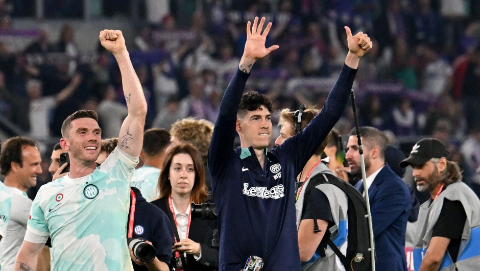Inter Milan's German midfielder Robin Gosens(L) and Inter Milan's Italian defender Alessandro Bastoni (R) celebrate after their victory in the Italian Cup (Coppa Italia) final football match between Fiorentina and Inter Milan at the Stadio Olimpico in Rome, on May 24, 2023. (Photo by Alberto PIZZOLI / AFP)