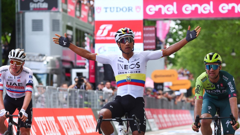 Winner Team Ineos' Ecuadorian Jhonatan Narvaez (C), flanked by second placed Team Bora's German rider Maximilian Schachmann (R) and third placed Team UAE's Slovenian rider Tadej Pogacar (L), celebrates as he winsthe stage 1 of the Giro d'Italia 2024 cycling race, 140 km between Venaria Reale and Turin on May 4, 2024. The 107th edition of the Giro d'Italia, with a total of 3400,8 km, departs from Veneria Reale near Turin on May 4, 2024 and will finish in Rome on May 26, 2024. (Photo by Luca Bettini / AFP)