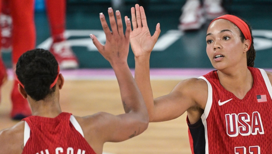 USA's #09 A'ja Wilson and USA's #11 Napheesa Collier celebrate in the women's Gold Medal basketball match between France and the USA during the Paris 2024 Olympic Games at the Bercy  Arena in Paris on August 11, 2024. (Photo by Damien MEYER / AFP)