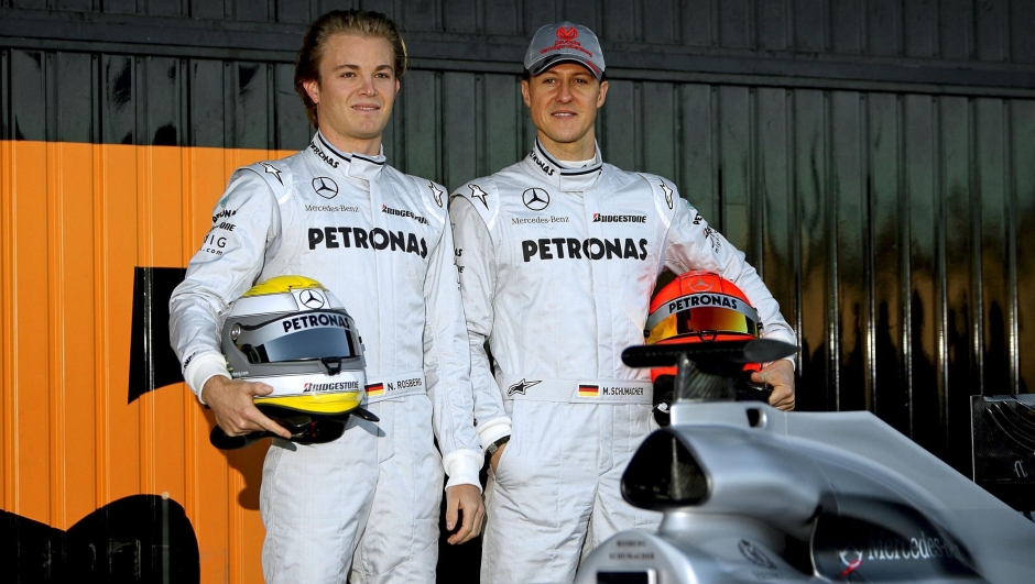 epa02014071 German F-1 drivers Michael Schumacher (R) and Nico Rosberg (L), of Mercedes GP team, pose next to the new Mercedes race car during a training session at Ricardo Tormo circuit in Cheste, outside Valencia, eastern Spain, 01 February 2010. Rosberg will be first behind the wheel in the morning test session before seven-time champion Schumacher steps in later in the day. Formula One teams are taking part in a three-day test session, the first of four this month before the season begins in Bahrain on March 14. All the leading teams are in Valencia apart from Red Bull which will launch its car on February 10.  EPA/KAI FORSTERLING