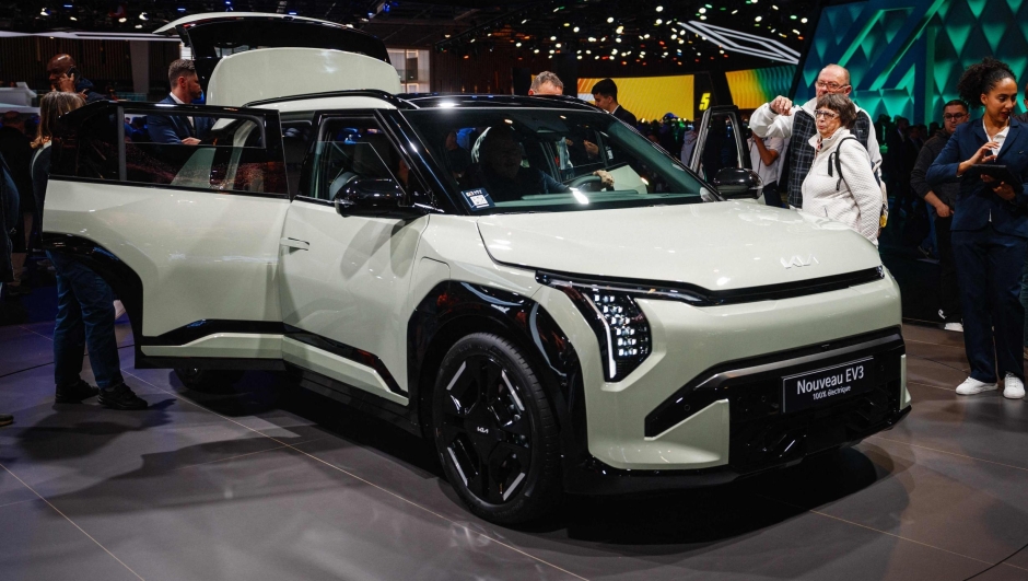 Visitors look at a Kia EV3 electric car presented at the Paris Motor Show at Paris Expo, Porte de Versailles in Paris on October 15, 2024. (Photo by Dimitar DILKOFF / AFP)