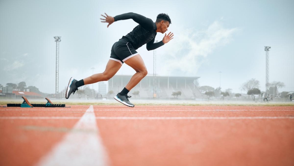 Man, athlete and ready for race on track with practice, training or exercise for competition. Black person, runner and fast with dedication, determination and passion on face with speed for sport