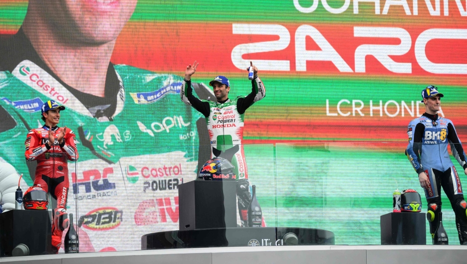 LCR Honda team's French MotoGP rider Johann Zarco (C) poses on the podium with second placed Ducati Lenovo Team's Spanish MotoGP rider Marc Marquez (L), and third place BK8 Gresini Racing MotoGP team's Spanish MotoGP rider Fermin Aldeguer, after winning the MotoGP World Championship, at the Le Mans Circuit on May 11, 2025. (Photo by Loic VENANCE / AFP)