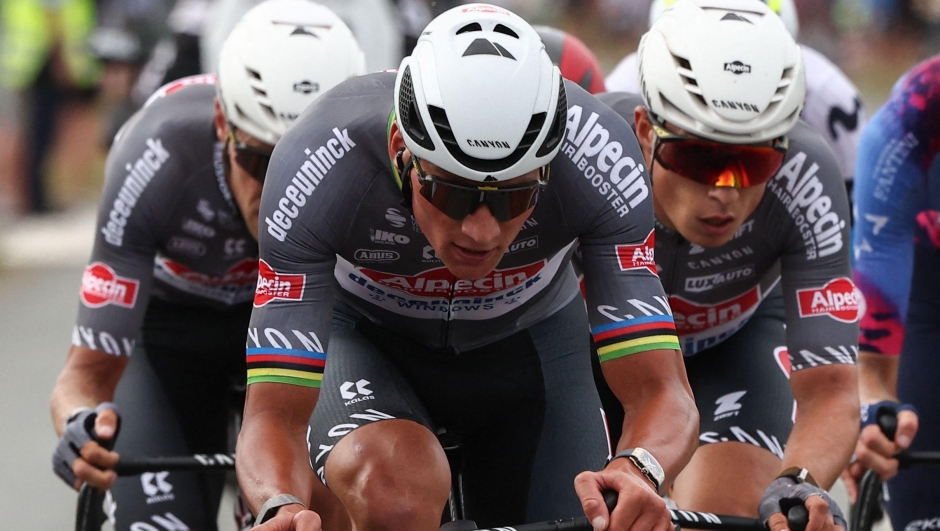 (From L) Guest, Alpecin - Deceuninck team's Dutch rider Mathieu van der Poel (C) and Alpecin - Deceuninck team's Belgian rider Jasper Philipsen (R) cycle with the pack of riders (peloton) during the 1st stage of the 112th edition of the Tour de France cycling race, 184.9 km starting and finishing in Lille Metropole, northern France, on July 5, 2025. (Photo by Anne-Christine POUJOULAT / AFP)