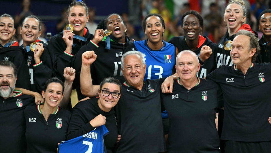 Gold medallists Italy's players, Italy's head coach Julio Velasco and staff pose during the award ceremony for the women's volleyball follwing the gold medal match between USA and Italy at the South Paris Arena 1 in Paris during the Paris 2024 Olympic Games on August 11, 2024. (Photo by Natalia KOLESNIKOVA / AFP)