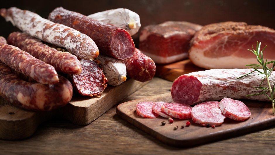 Various kind types of salami, speck and sausages on a wooden table