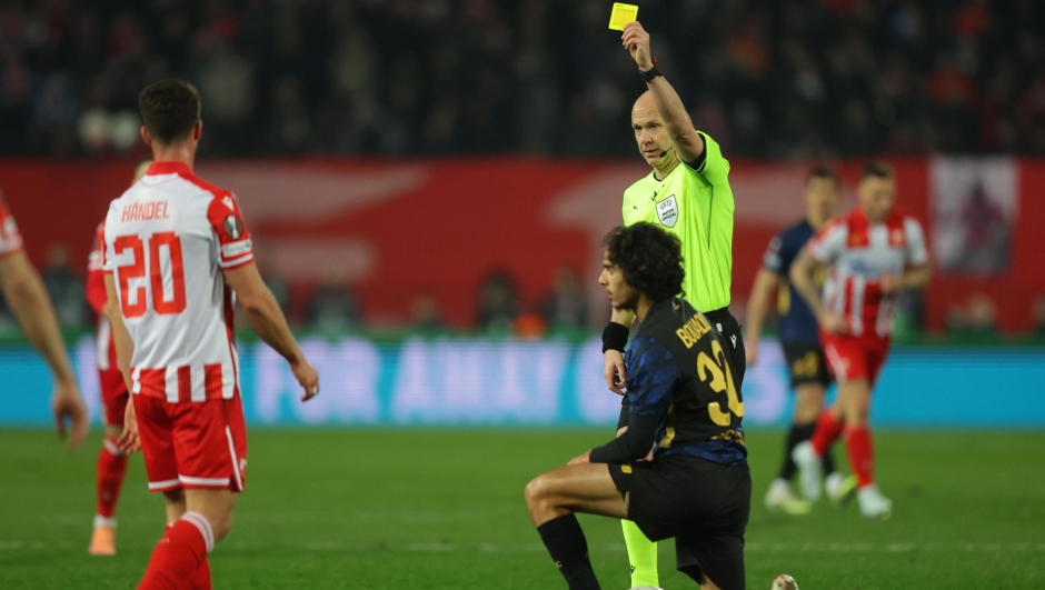epa12779096 Referee Anthony Taylor (in green) shows a yellow card to Crvena zvezda's Tomas Handel (L) during the UEFA Europa League play-offs 2nd leg match between Crvena zvezda and Lille OSC, in Belgrade, Serbia, 26 February 2026.  EPA/ANDREJ CUKIC