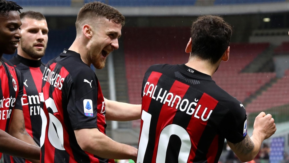  Hakan Calhanoglu of A.C. Milan celebrates with team mates after scoring their sides first goal with team mate Alexis Saelemaekers during the Serie A match between AC Milan  and US Sassuolo at Stadio Giuseppe Meazza on April 21, 2021 in Milan, Italy.Sporting stadiums around Italy remain under strict restrictions due to the Coronavirus Pandemic as Government social distancing laws prohibit fans inside venues resulting in games being played behind closed doors. (Photo by Marco Luzzani/Getty Images)