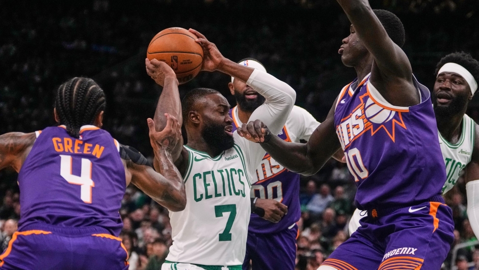 Boston Celtics guard Jaylen Brown (7) is surrounded on a drive to the basket against the Phoenix Suns during the first half of an NBA basketball game, Monday, March 16, 2026, in Boston. (AP Photo/Charles Krupa)