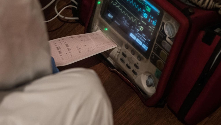  A paramedic from Turkey’s 112 Emergency Healthcare services (EHS) looks at a an ECG print out of a patient with COVID-19 symptoms at an apartment in the “red zone” district of Bahcelievler on May 02, 2020 in Istanbul, Turkey.  Since the first reported Covid-19 case in Turkey on March 11, the 112 EHS has seen a rise in calls from 20,000 per day to between 35,000 and 40,000. The majority of Covid-19 cases in Turkey have been recorded in Istanbul. The city's 112 emergency healthcare services have been working around the clock, with more than 5000 EMT’s, paramedics and doctors based in 181 stations citywide. The EHS teams work in 24-hour shifts and wear full personal protective equipment (PPE) for every call. These teams are the first to respond when a Covid-19 case comes in and are responsible for entering a patient’s house and assessing the severity of the symptoms before treating them and transporting them to the nearest hospital. In the first months of the pandemic, EHS teams working in “red zone” neighborhoods with the highest number of positive cases were responding to twenty or more Covid-19 cases per day, sometimes as many as thirty. The number of cases has dropped in recent weeks, giving the crews some respite after months of intense shifts, but the risk of infection for frontline workers is still high. Turkey’s Health Minister Fahrettin Koca announced in an April 29 press conference that 7,428 health care workers have become infected since the start of the pandemic. As of May 5, Turkey has recorded 3,520 Coronavirus related deaths, 129,491 confirmed cases and 73,285 recovered patients. (Photo by Chris McGrath/Getty Images)