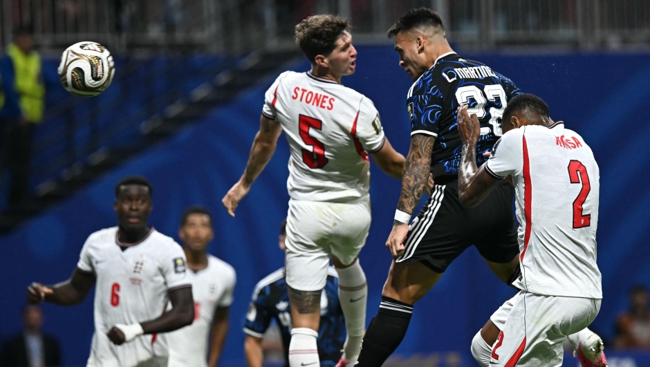 Argentina's forward #22 Lautaro Martinez (C) scores his team's second goal past England's defender #05 John Stones (L) and England's defender #02 Ezri Konsa during the 2026 World Cup football tournament semi-final match between England and Argentina at the Atlanta Stadium in Atlanta on July 15, 2026.  (Photo by Paul ELLIS / AFP)