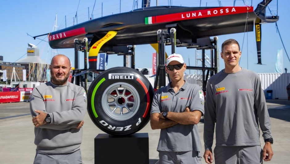 Gli uomini di Luna Rossa e il pneumatico di F1 tricolore all’asta, autografato dal team