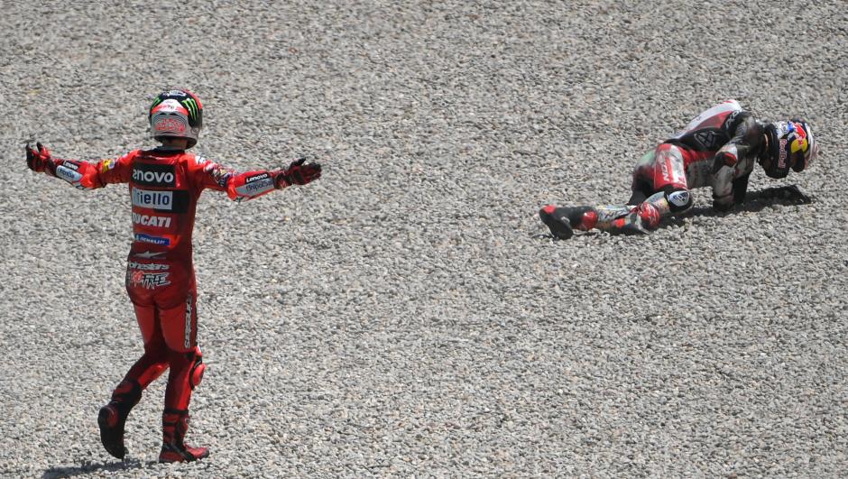 Ducati Italian rider Francesco Bagnaia (L) reacts as Honda LCR Japanese rider Takaaki Nakagami lies of the ground after falling during the Moto Grand Prix de Catalunya at the Circuit de Catalunya on June 5, 2022 in Montmelo on the outskirts of Barcelona. (Photo by LLUIS GENE / AFP)