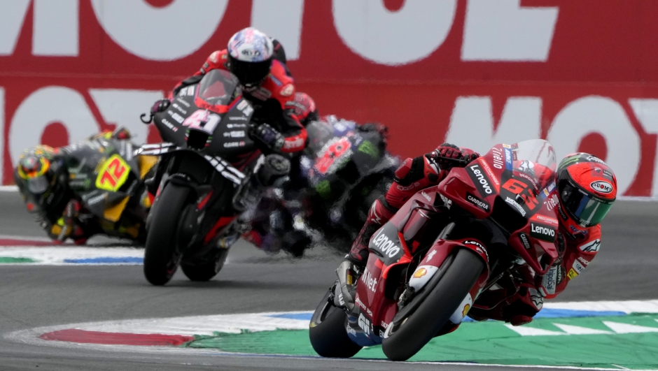 Italian rider Francesco Bagnaia of the Ducati Lenovo Team steers his motorcycle followed by Spain's rider Aleix Espargaro of the Aprilia Racing during the MotoGP race at the Dutch Grand Prix in Assen, northern Netherlands, Sunday, June 26, 2022. (AP Photo/Peter Dejong)