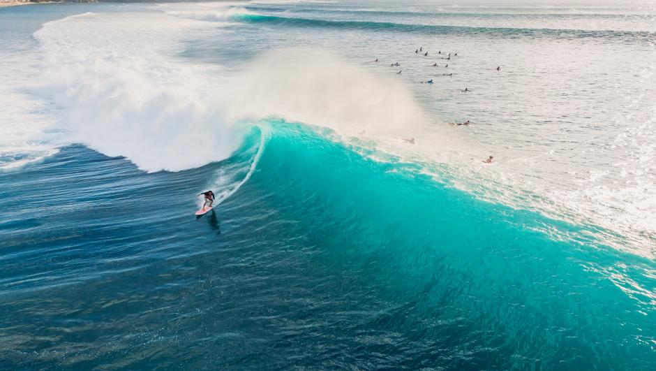 Aerial view with surfing on ideal barrel wave. Blue perfect waves and surfers in ocean