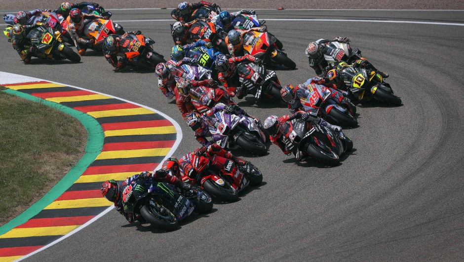 Monster Energy Yamaha's French rider Fabio Quartararo (L) leads the pack through the first corner of the German MotoGP Grand Prix at the Sachsenring racing circuit in Hohenstein-Ernstthal near Chemnitz, eastern Germany, on June 19, 2022. (Photo by Ronny Hartmann / AFP)