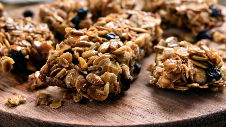 Granola pieces on wooden board, close up view