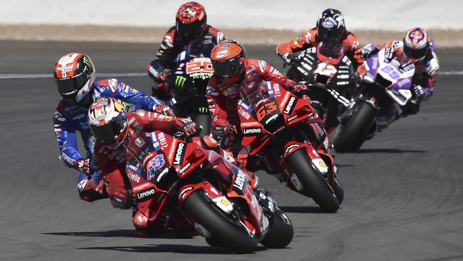 Australian rider Jack Miller of the Ducati Lenovo Team steers his motorcycle followed by Spain's rider Alex Rins of the Team SUZUKI ECSTAR and Italian rider Francesco Bagnaia of the Ducati Lenovo Team during the MotoGP race at the British Motorcycle Grand Prix at the Silverstone racetrack, in Silverstone, England, Sunday, Aug. 7, 2022. (AP Photo/Rui Vieira)