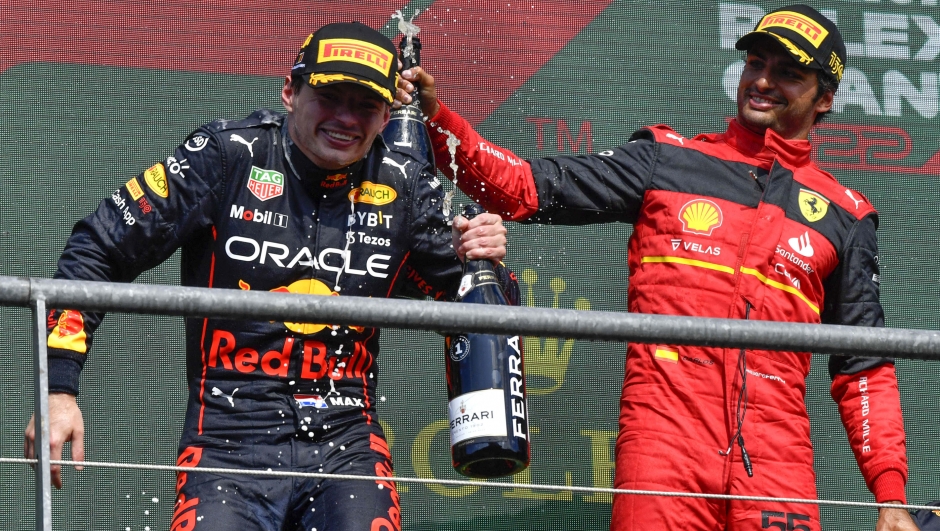 First place Red Bull driver Max Verstappen of the Netherlands, left, celebrates on the podium with third place Ferrari driver Carlos Sainz of Spain during the Formula One Grand Prix at the Spa-Francorchamps racetrack in Spa, Belgium, Sunday, Aug. 28, 2022. (AP Photo/Geert Vanden Wijngaert)