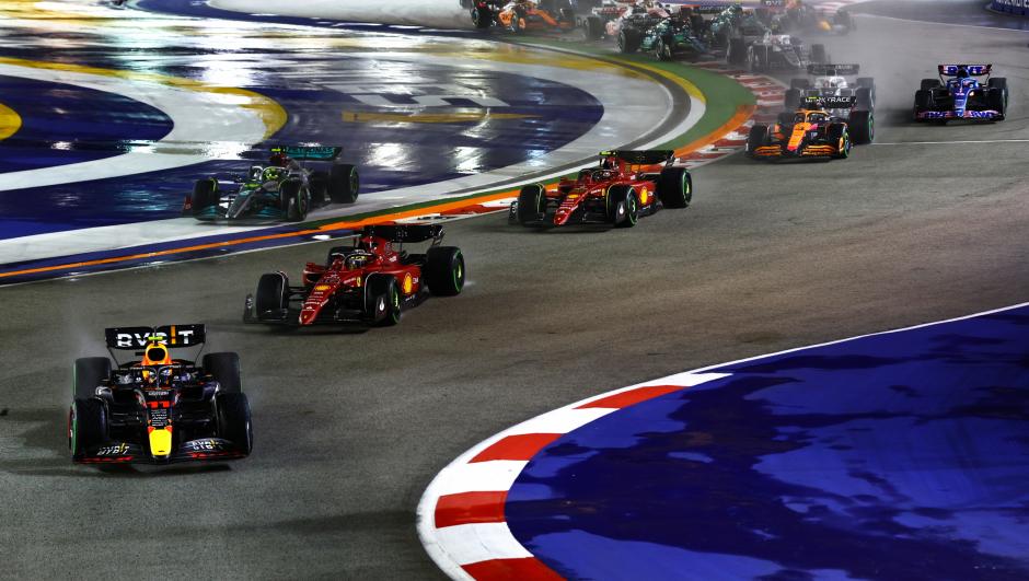 SINGAPORE, SINGAPORE - OCTOBER 02: Sergio Perez of Mexico driving the (11) Oracle Red Bull Racing RB18 leads Charles Leclerc of Monaco driving the (16) Ferrari F1-75 and the rest of the field at the start during the F1 Grand Prix of Singapore at Marina Bay Street Circuit on October 02, 2022 in Singapore, Singapore. (Photo by Mark Thompson/Getty Images,)