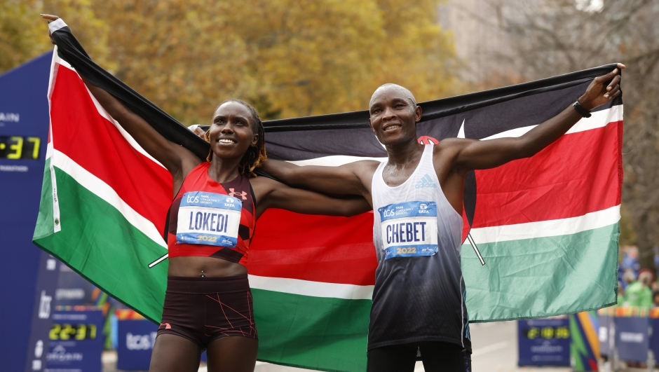 Women's division winner Sharon Lokedi, of Kenya, and men's division winner Evans Chebet, of Kenya, pose at the finish line of the New York City Marathon, Sunday, Nov. 6, 2022, in New York. (AP Photo/Jason DeCrow)