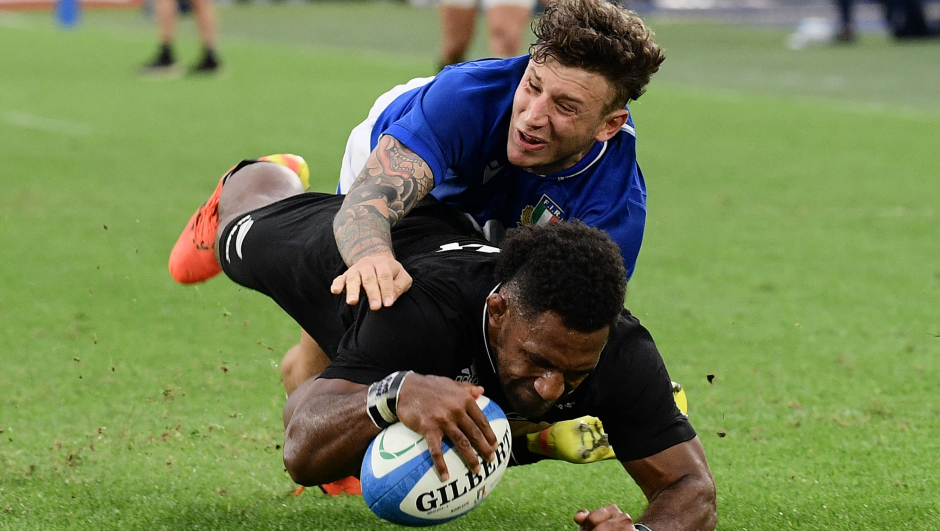 Italy's full-back Matteo Minozzi (TOP) tackles New Zealand's right wing Sevu Reece as he scores a try during the autumn international rugby union Test match between Italy and New Zealand at Stadio Olimpico in Rome on November 6, 2021. (Photo by Filippo MONTEFORTE / AFP)