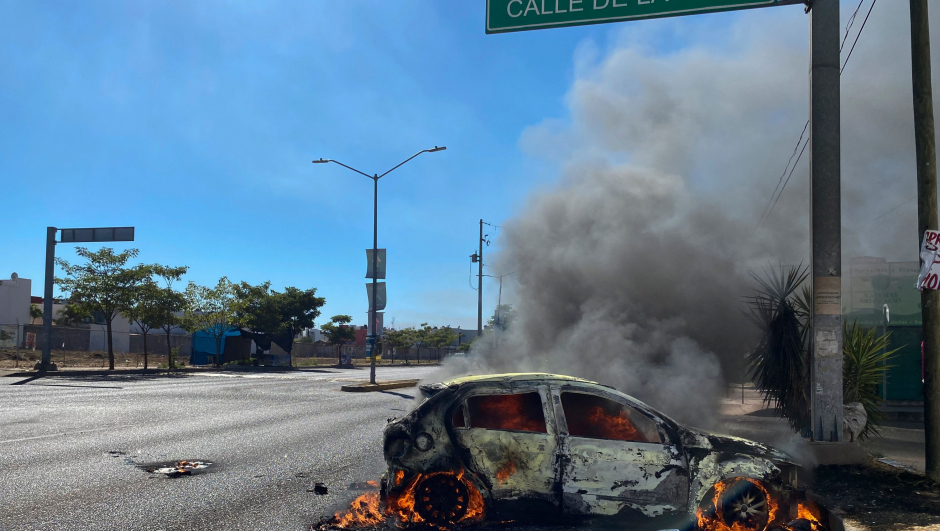 TOPSHOT - A burning car is seen on the street during an operation to arrest the son of Joaquin "El Chapo" Guzman, Ovidio Guzman, in Culiacan, Sinaloa state, Mexico, on January 5, 2023. - Mexican security forces on Thursday captured a son of jailed drug kingpin Joaquin "El Chapo" Guzman, scoring a high-profile win in the fight against powerful cartels days before US President Joe Biden visits. Ovidio Guzman, who was arrested in the northwestern city of Culiacan, is accused of leading a faction of his father's notorious Sinaloa cartel, Defense Minister Luis Cresencio Sandoval told reporters. (Photo by Juan Carlos CRUZ / AFP)