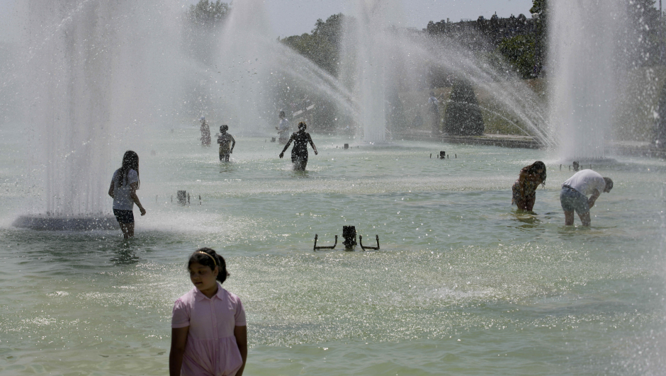 People cool down in the fountains of the Trocadero gardens in Paris as Europe is under an unusually extreme heat wave, Tuesday, July 19, 2022. (AP Photo/Christophe Ena)