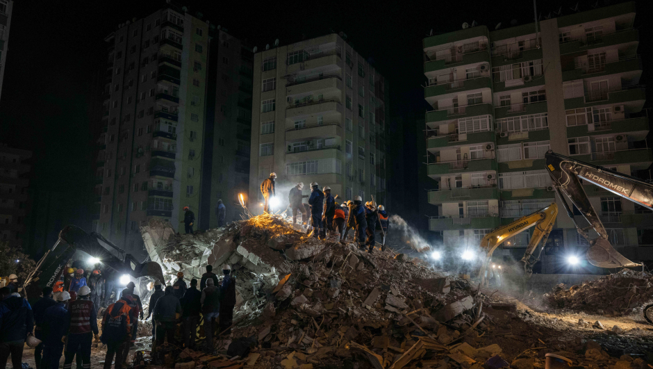 Rescue workers search for bodies and earthquake survivors on a collapsed building in Adana, southeastern Turkey, Friday, Feb. 10, 2023. Some 12,000 buildings in Turkey have either collapsed or sustained serious damage, according to Turkey?s minister of environment and urban planning, Murat Kurum.(AP Photo/Bernat Armangue)