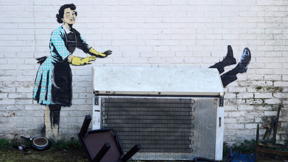 An artwork, acknowledged to by street artist Banksy, is pictured on the side of a house in Margate, south east England on February 14, 2023. - The artwork appears to show a a 1950s housewife with a swollen eye, missing a tooth, and apparently shutting a man in a freezer. The freezer was later removed by council workers. (Photo by William EDWARDS / AFP) / RESTRICTED TO EDITORIAL USE - MANDATORY MENTION OF THE ARTIST UPON PUBLICATION - TO ILLUSTRATE THE EVENT AS SPECIFIED IN THE CAPTION
