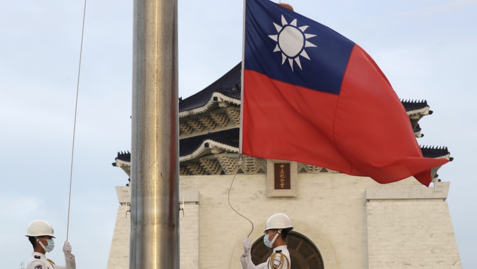 FILE - Two soldiers lower the national flag during the daily flag ceremony on Liberty Square of the Chiang Kai-shek Memorial Hall in Taipei, Taiwan, July 30, 2022. China sent 25 warplanes and three warships toward Taiwan on Wednesday, March 1, 2023, the island's Defense Ministry said, as tensions remain high between Beijing and Taipei's main backer Washington. (AP Photo/Chiang Ying-ying, File)