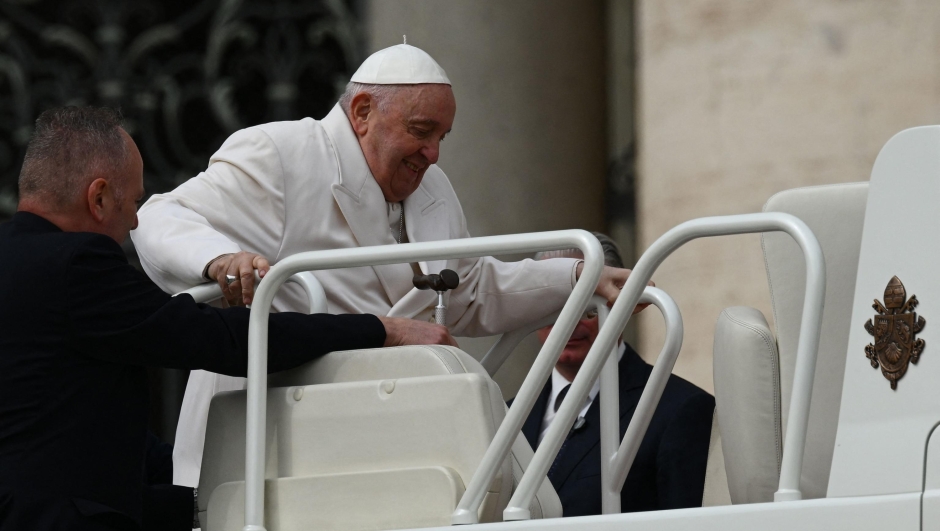Pope Francis is helped get up the popemobile car as he leaves on March 29, 2023 at the end of the weekly general audience at St. Peter's square in The Vatican. (Photo by Vincenzo PINTO / AFP)