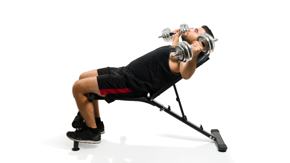 Profile of a strong hispanic young man doing bench chest fly exercises with dumbbell weights