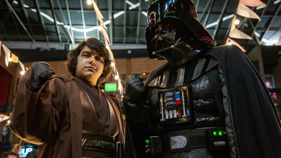 Fans dressed as characters of the film Star Wars, Luke Skywalker (L) and Darth Vader (R), celebrate the Star Wars Day, at the Plaza de las Americas, in Quito, on May 4, 2022. (Photo by Cristina Vega RHOR / AFP)