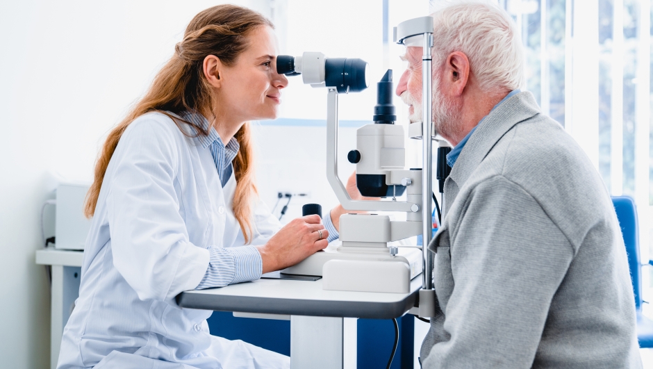Female ophthalmologist examining mature man`s eyes