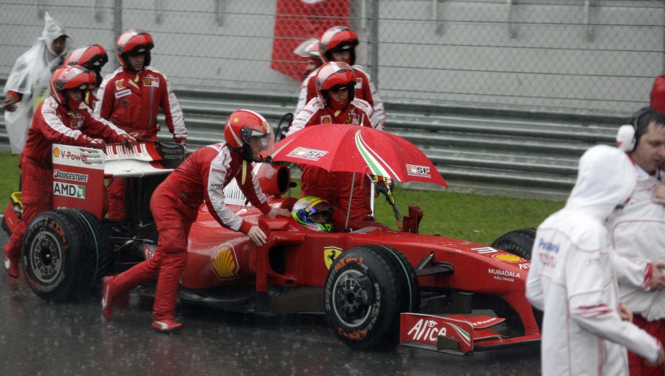 Brazilian driver Felipe Massa of Ferrari sits in his car as the pit crew push it away after heavy rain stooped the Malaysian F1 Grand Prix at the Sepang International Circuit on April 5, 2009. Jenson Button won a chaotic Malaysian Grand Prix for a second straight victory after the race was abandoned when a ferocious storm lashed the Sepang circuit.   AFP PHOTO/POOL/ BAZUKI MUHAMMAD  RESTRICTED TO EDITORIAL USE GETTY OUT