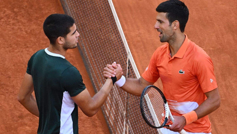TOPSHOT - Spain's Carlos Alcaraz (L) and Serbia's Novak Djokovic shake hands at the end of their 2022 ATP Tour Madrid Open tennis tournament men's singles semi-final match at the Caja Magica in Madrid on May 7, 2022. (Photo by GABRIEL BOUYS / AFP)